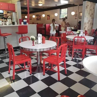 a checkered floor with red chairs