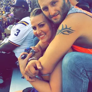 a man and a woman hugging at a baseball game
