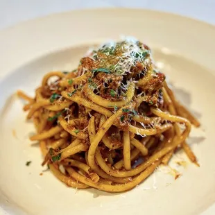 a plate of spaghetti with meat and parmesan cheese