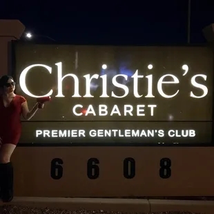 a woman standing in front of a sign