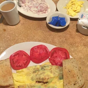 Omlette with tomato, spinich, mushroom, and feta cheese with a side of consistently the best sliced tomatoes and rye toast.