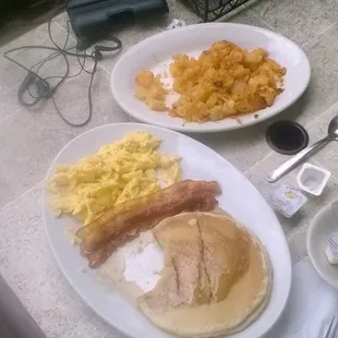 2 eggs , 2 bacon , 2 pancakes , and a side order of home fries with a glass of water .