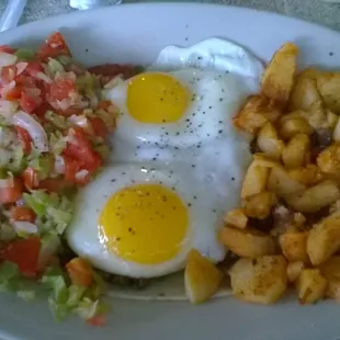Huevos Ranchetos with home fries . So good but can be very messy to eat .