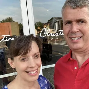 a man and a woman standing in front of a store