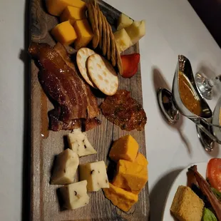 a cutting board with various types of cheese and meat