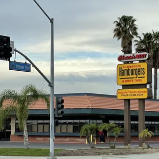a restaurant with palm trees in the background