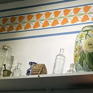 The decor is relaxing with objects from Greece lining shelves and relaxing colors.