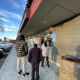 a group of people standing outside of a store