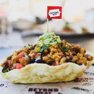 a taco topped with meat and guacamole