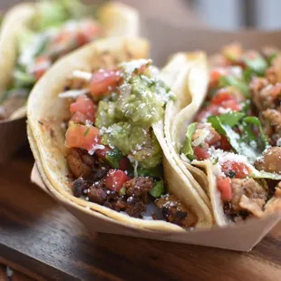 two tacos on a cutting board