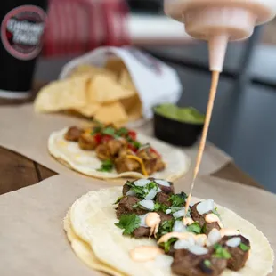 a person putting sauce on a taco