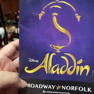 a hand holding a copy of the broadway musical