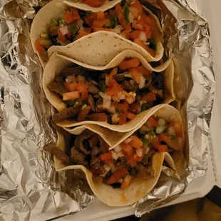 3 Steak tacos with salsa on top.