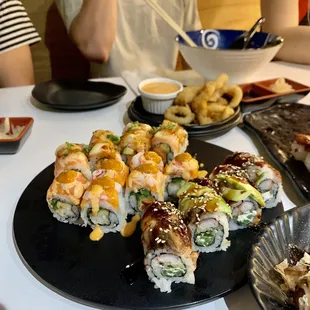 a plate of sushi with a side of fries