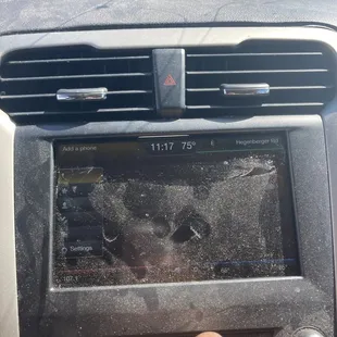 a person's hand pressing a button on a car's dashboard