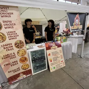two people standing under a tent
