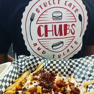 a man holding a basket of fries