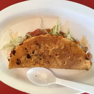 a taco with lettuce and a spoon