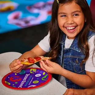 a young girl eating a slice of pizza