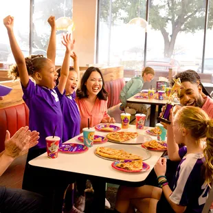 a group of people sitting at a table in a fast food restaurant