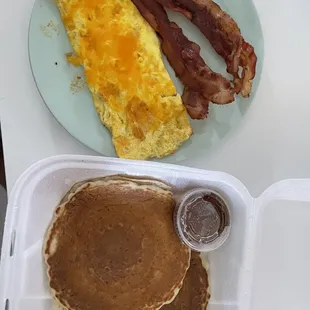 a breakfast of pancakes, bacon and eggs