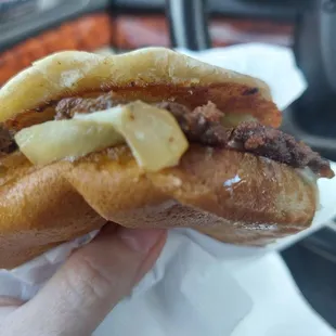 a person holding a sandwich in their hand