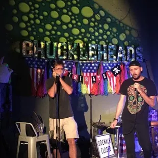 two men on stage with microphones