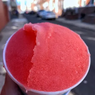 a person holding a cup of watermelon