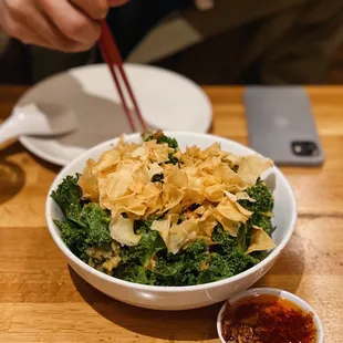 a person holding chopsticks over a bowl of food