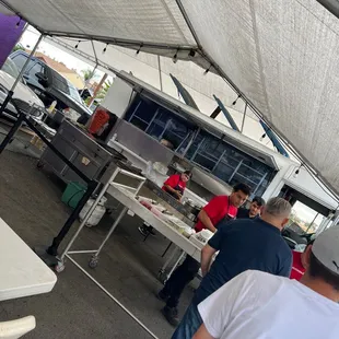 people preparing food under a tent