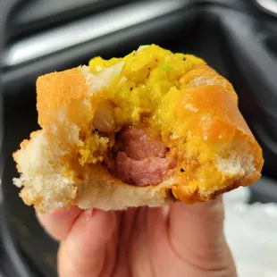 a hand holding a hot dog