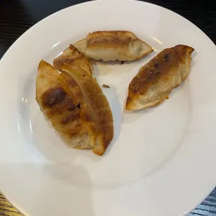 three dumplings on a white plate