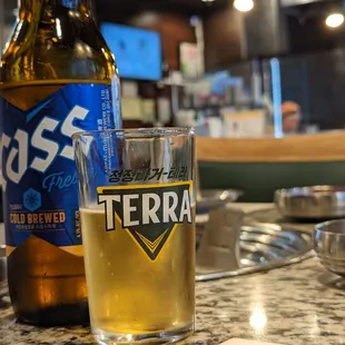 a glass of beer and a bottle of beer sitting on a