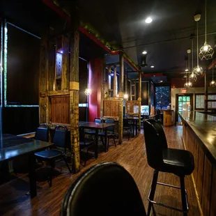 a dimly lit restaurant with wooden tables and chairs