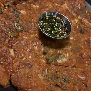 a plate of food with a small bowl of sauce