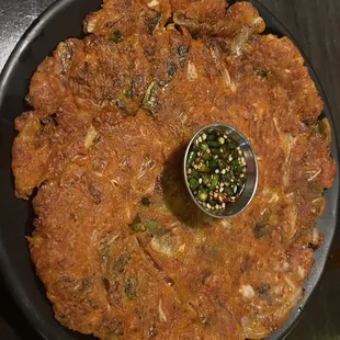 a plate of food with a small bowl of sauce