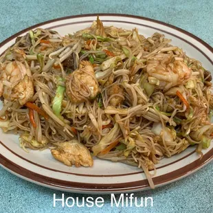 a plate of noodles with shrimp and vegetables