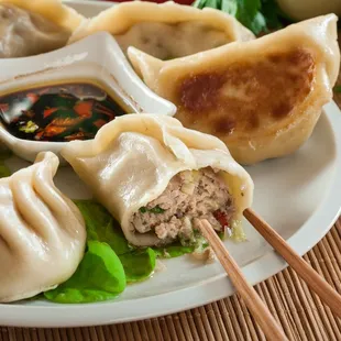 a plate of dumplings with dipping sauce