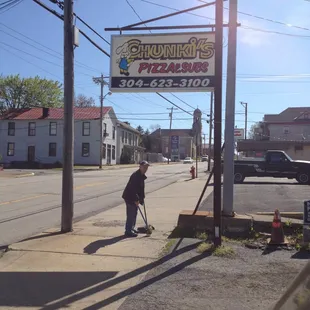 a man sweeping the sidewalk