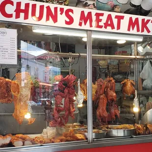 Glass showcase with different meats and prices.