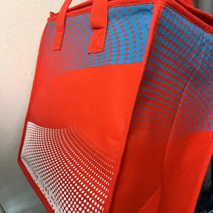 a red tote bag with a blue and white design