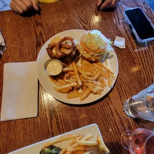 a man sitting at a table with a plate of food and a glass of wine