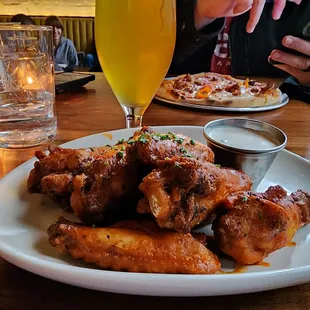 a plate of chicken wings and a glass of beer