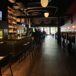 the interior of a bar with people sitting at the bar
