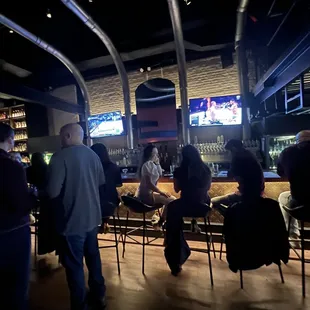 a group of people sitting at a bar