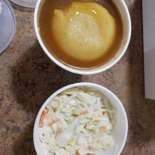 Mashed potatoes with gravy and coleslaw.