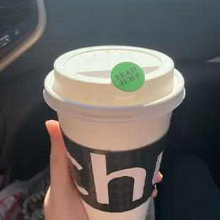 Latte with a Bean Juice sticker to avoid spills