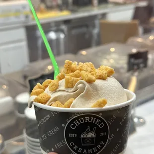 a hand holding a cup of ice cream