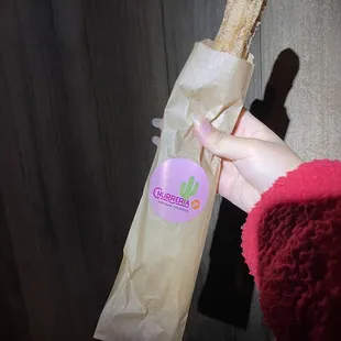 a person holding a bag of bread