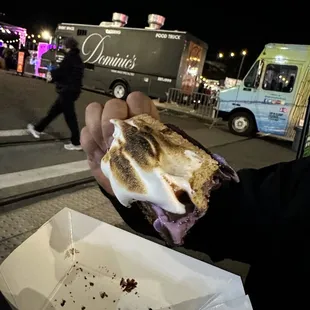 a hand holding a half eaten sandwich